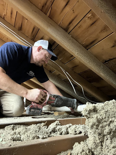 A man in a blue shirt working on a ceiling