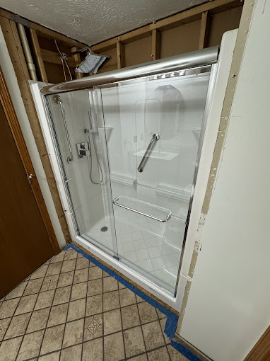 A bathroom with a shower and tiled floor