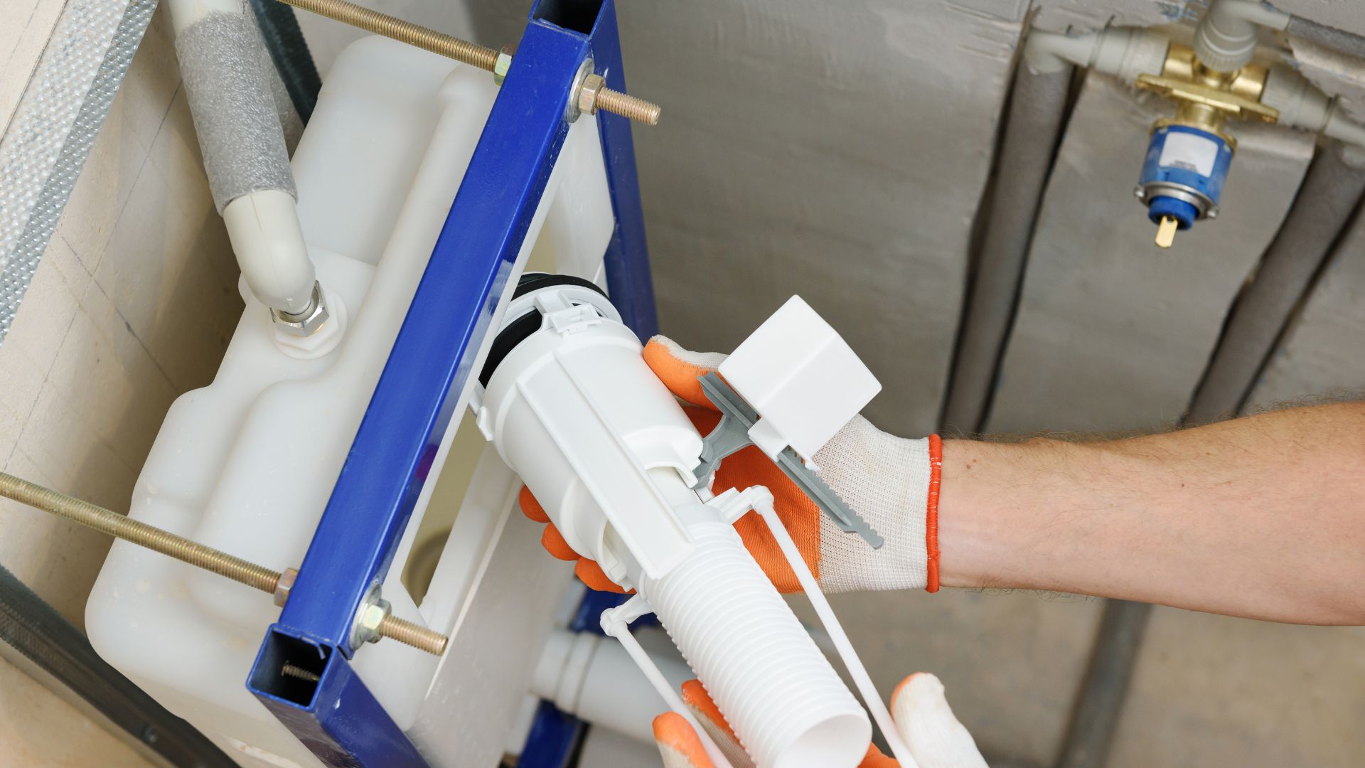 A person is fixing a pipe in a bathroom