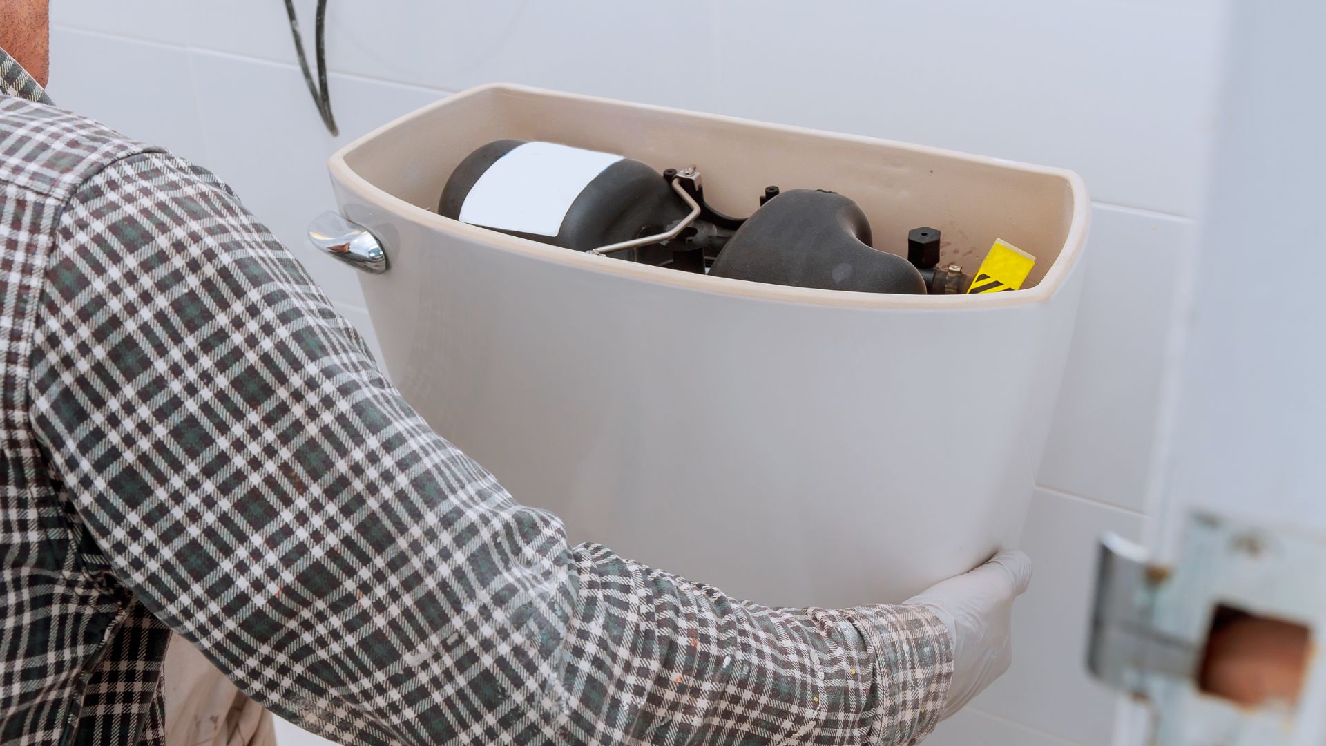 A man in plaid shirt holding a bucket with various items in it