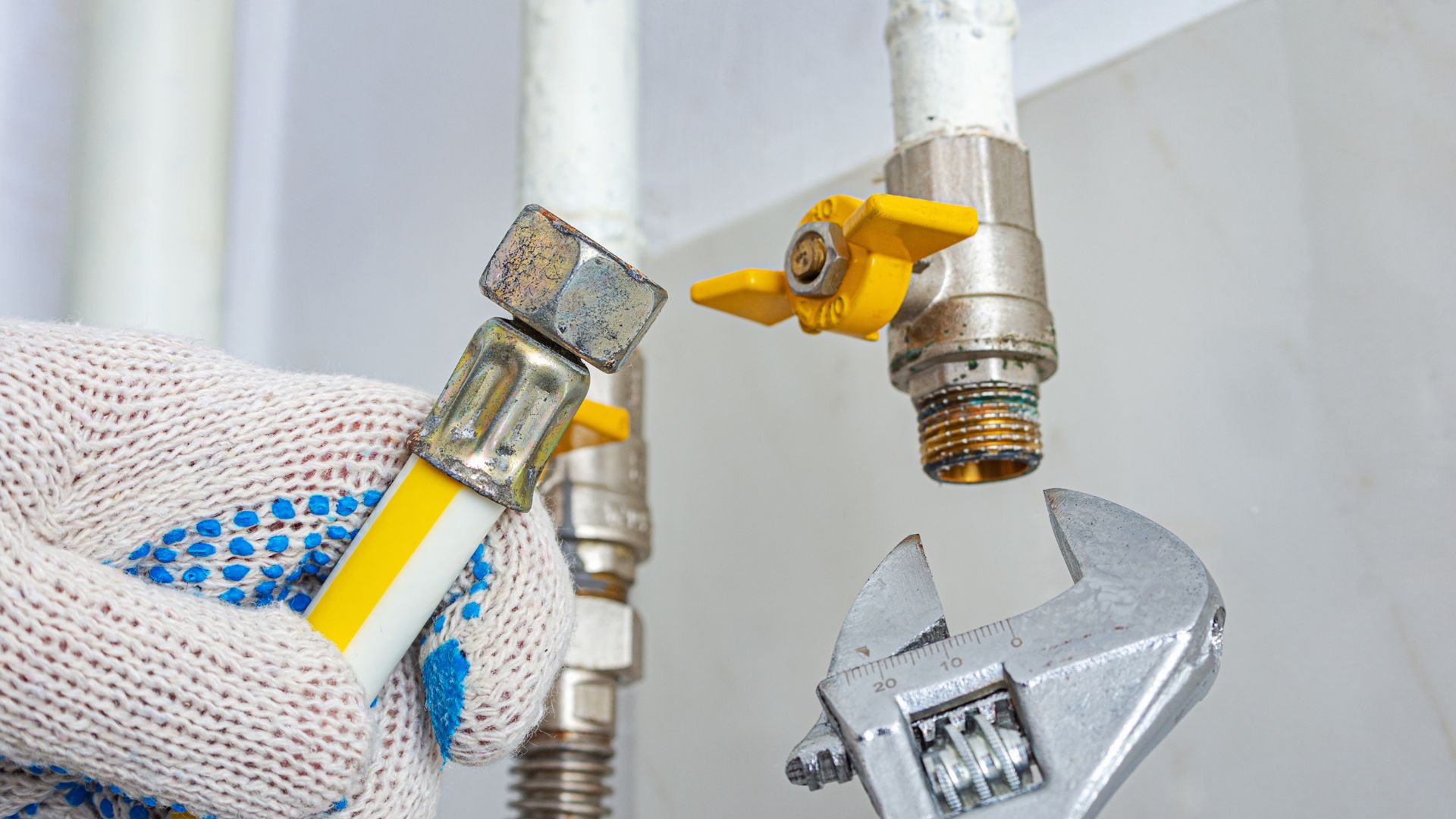 A person holding a wrench and a pipe wrench